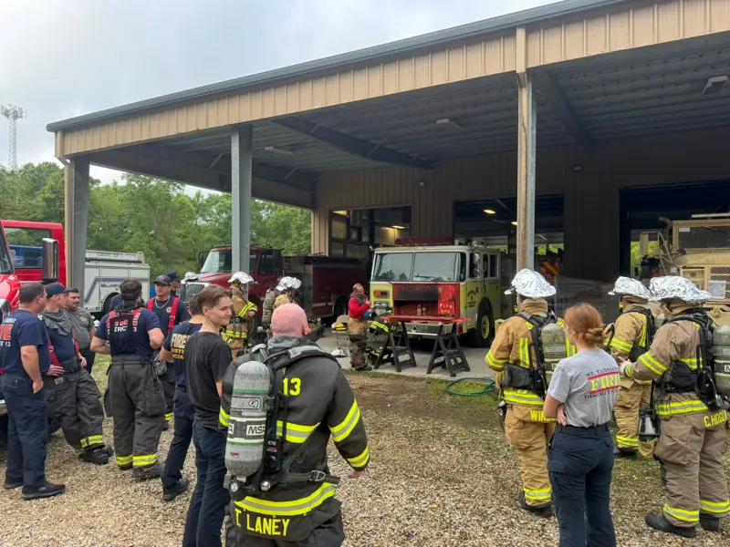 Crews in turnout gear training in front of the apparatus bay