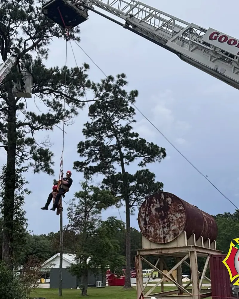 A rescuer and Stokes basket lowered from the aerial ladder