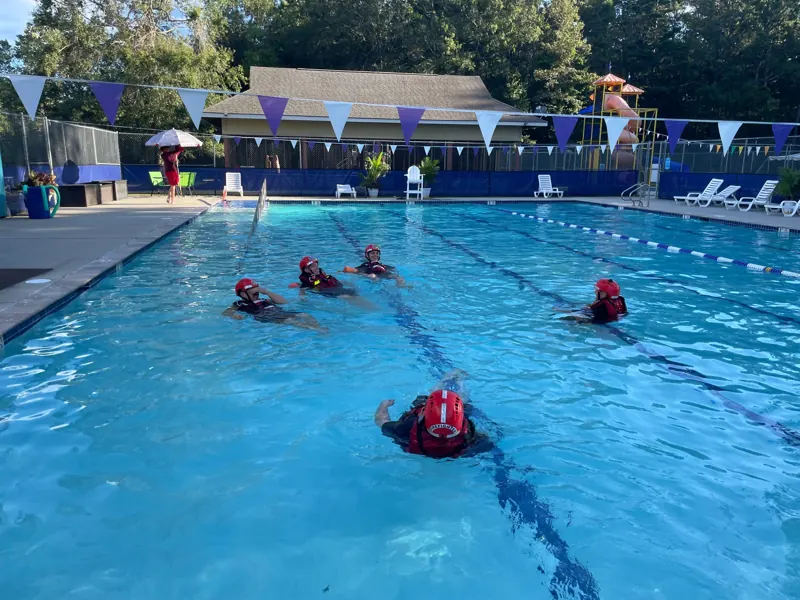 Firefighters practicing a swimming rescue in a pool